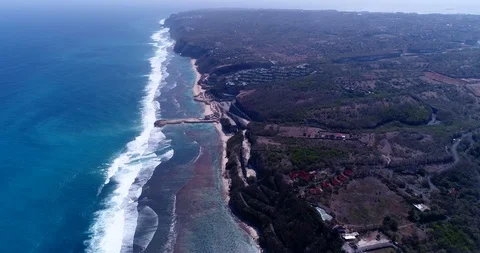Shallow reef with turquoise water, waves crashing and cliffs on coast Stock Footage 114604795