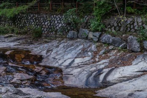 Shallow river cascading over large boulder Stock Photos