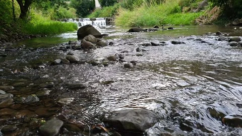 Shallow Stream Flowing with Stone Dam Weir Visible in the Distance Stock Footage 340051386