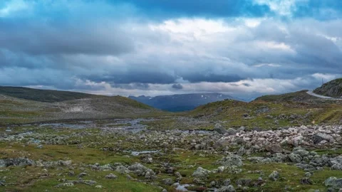 A shallow stream flows through the mountain plateau covered with scarce Stock Footage 270224376