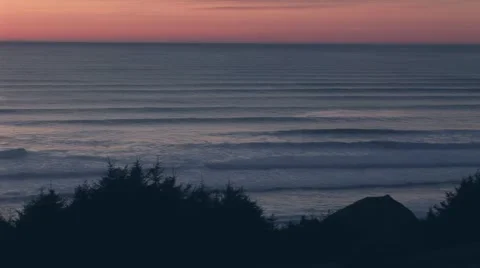 Shallow waves rolling ashore with orange sky, Oregon USA Stock Footage 60407653