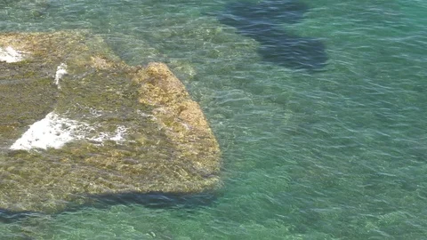 Shallow Waves Wash Over Submerged Rock In Clear Sea - From Above Video stock 109227585