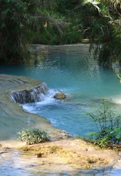 Shallows of a blue river in a forest. Stock Photos