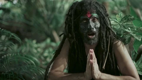 Shaman with dreadlocks chanting in the forest painted face Stock Footage 289599355