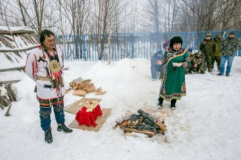 The shaman performs the rite of offering to the spirits by the fire. Stock Photos