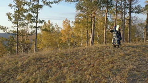Shaman playing a tambourine on a rock Stock Footage 303419853