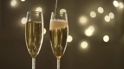 Сhampagne is poured into glasses, Christmas background. Slow motion. Stock Footage