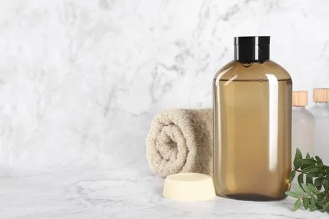 Shampoo bottle, essential oils, folded towel and solid shampoo bar on white.. Stock Photos