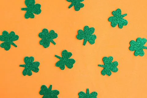 Shamrocks pattern on bright orange background. Minimal concept. Happy St. Pat Stock Photos