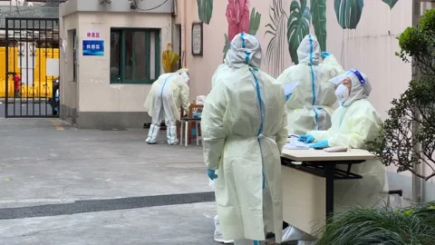 SHANGHAI, CHINA - APRIL 4, 2022: people in hazmat suits get ready to test covid Stock Footage 174556527