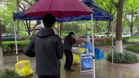 Shanghai Covid lockdown nucleic acid testing in the rain in resident compound 7 Stock Footage 185850973