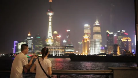 SHANGHAI - Sep 10, 2013: people stay at bund, admire scenic view of buildings at Stock Footage 107052425