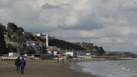 Shanklin seafront, late afternoon light, couple walking on beach, low tide Stock Footage 238722021