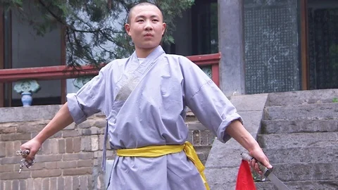 Shaolin monk practicing Kung Fu with weapons Видео 89813174