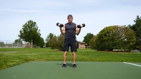 In shape man doing regular and hammer curls in the park, 4k, 60fps. Stock Footage 115272270