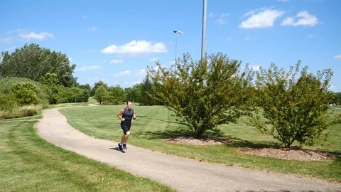 In shape man running on path outside on beautiful summer day, 4k. Stock Footage 115272852