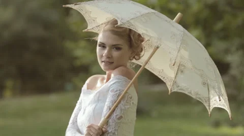 Shapely bride posing with an umbrella on the nature Stock Footage 47808491