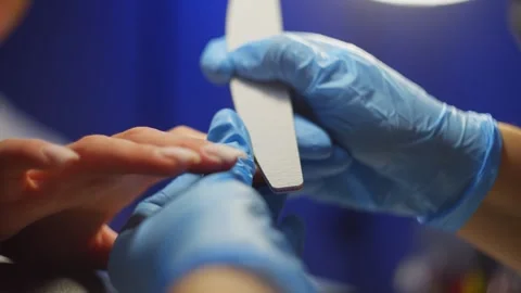 Shaping a beautiful nail plate using a nail file in a beauty salon. Stock Footage 343528731
