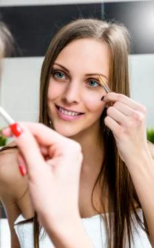 Shaping eyebrows with tweezer. Stock Photos