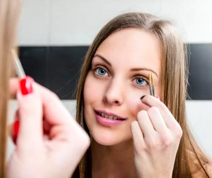 Shaping eyebrows with tweezer. Stock Photos
