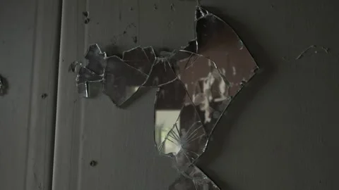 Shards of broken mirror on grey dark wall with augment of ruined room. War and d Stockbeeldmateriaal 247177713