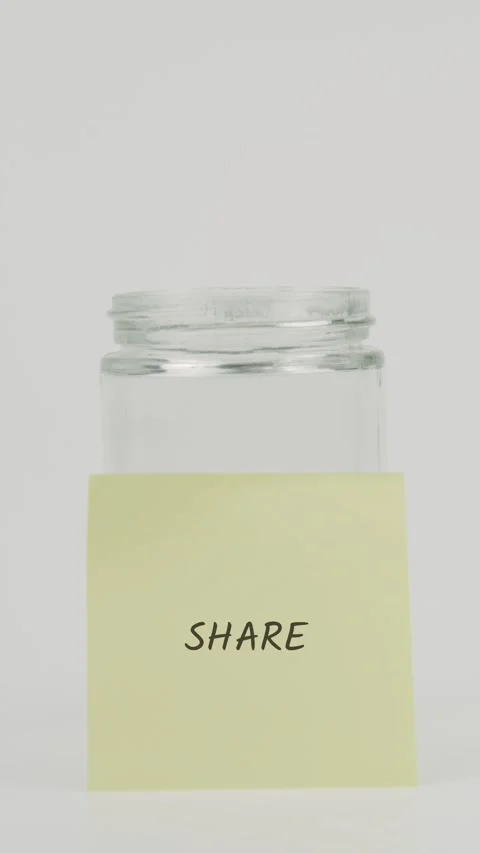 Share text or word on yellow sticky note attached to glass jar with hand Stock Footage 311785629