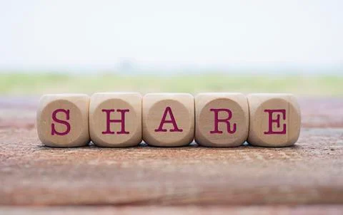 SHARE word written on cube shape wooden blocks on wooden table.  Stock Photos