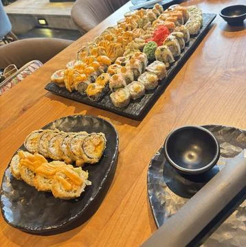 Shared Dining Table with Assorted Sushi Rolls Stock Photos