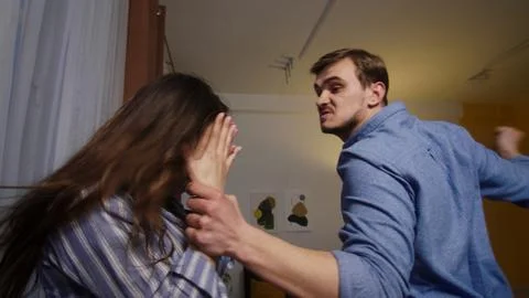 Shared Grief: Man Comforts Grieving Woman by the Window at Home Stock Photos