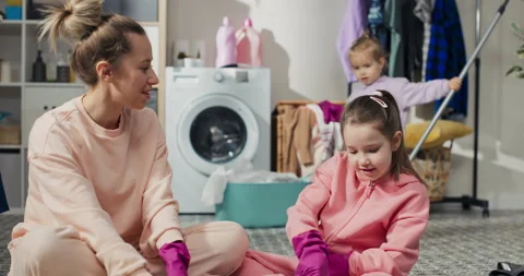 Shared laundry room bathroom cleaning. Mom and two daughters high-five with 库存影片 201103332