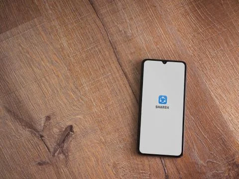 SHAREit app launch screen with logo on the display of a black mobile smartpho Stock Photos