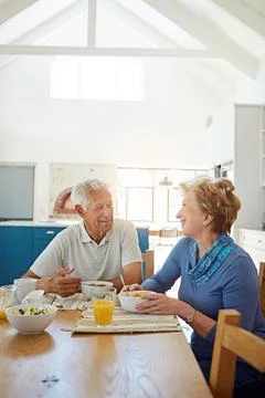 Sharing breakfast with her beloved. a happy mature couple having breakfast Stock Photos