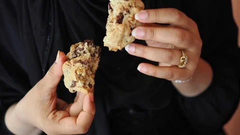 Sharing a chocolate chip cookie in a close setting Stock Footage 340543981