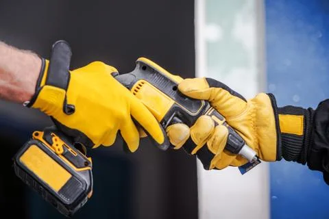 Sharing Construction Equipment Between Two Contractors in Safety Gloves.  Stock Photos