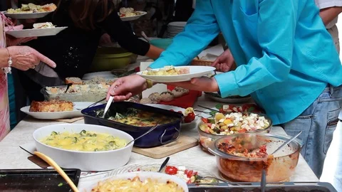 Sharing food at a potluck table Stock Footage 103056934