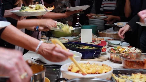Sharing food at a potluck table Stock Footage
