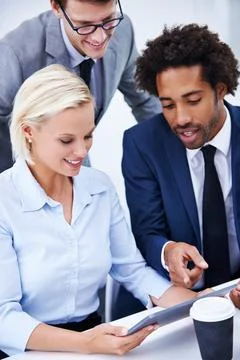 Sharing the latest software updates. a group of businesspeople looking at a Stock Photos