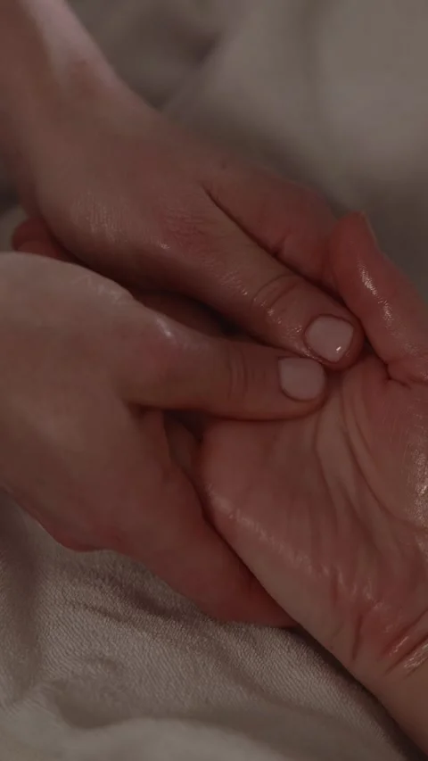Sharing a moment together with two hands touching gently on a soft surface Stock Footage 341281136