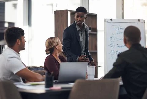 Sharing a new proposal with his team. a young businessman giving a presentation Stock Photos