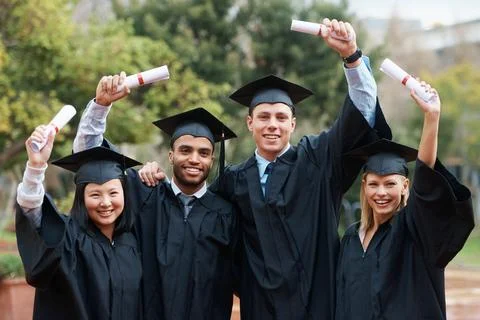 Sharing their accomplishments. A group of college graduates standing in cap and Stock Photos
