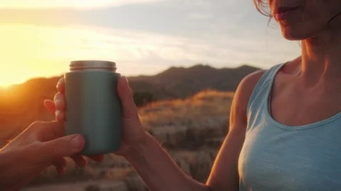 Sharing a warm mug during golden hour sunset over rolling hills, fostering .. Stock Footage 344688688