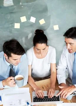 Sharing the workload. Group of businesspeople working together on a project. Stock Photos