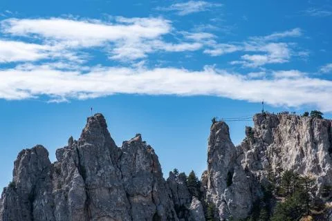 Sharp Ai-Petri cliffs with suspension bridge against a blue sky. Stock Photos