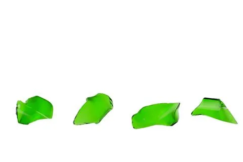 Sharp and jagged pieces of broken green glass cut out on a white background.. Stock Photos