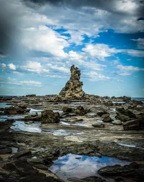 Sharp and rough cliff rocks emerging from the water of the Australian coast line 스톡 사진