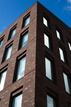 Sharp, angular view of modern brick residential building. The symmetrical d.. Stock Photos