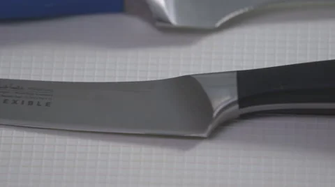 Sharp black handle Knife on a white surface pan Stock Footage 64027403
