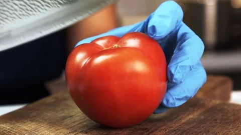 Sharp blade cut in half ripe red tomato on wooden board. Stock Footage 82359137