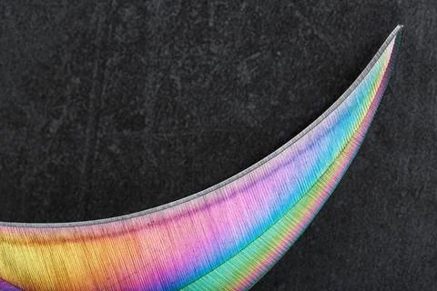 The sharp blade of the Kerambit knife made of steel is multicolored in close- Foto stock