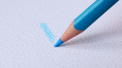 A sharp blue pencil draws on white textural paper Video stock 287565964